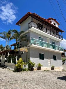 a house with a balcony on top of it at Estrela Premium Pousada in Gamboa