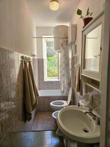 een badkamer met een wastafel, een toilet en een raam bij Casa di Marco in Irola