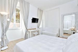 a white bedroom with a bed and a mirror at Prime Vatican Garden in Rome