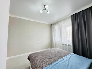 アスタナにあるMoD Standard 2-Room Apartmentsのベッドルーム1室(ベッド1台、シーリングファン付)
