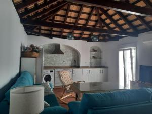 a living room with a blue couch and a kitchen at El rincón de Manolita #3 in Bornos