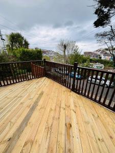 una terraza de madera con una valla encima en Captain's Nook, Luxurious Victorian Apartment with Four Poster Bed and Private Parking only 8 minutes walk to the Historic Harbour en Brixham