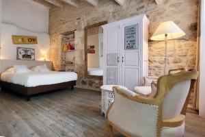 1 dormitorio con 1 cama y 1 silla en una habitación en La Martinoise Garden, en Saint-Martin-de-Ré