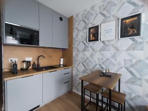 a kitchen with white cabinets and a small table at Ama Molto Apartments in Wrocław