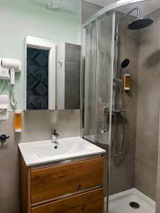a bathroom with a sink and a shower at Ama Molto Apartments in Wrocław