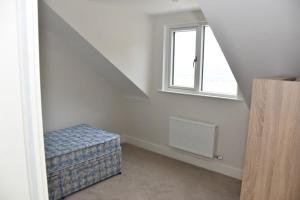 a white room with a bed and a window at Luxurious apartment near the sea in Dun Laoghaire