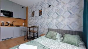a bedroom with a bed and a kitchen with a counter at Ama Molto Apartments in Wrocław +43 photos