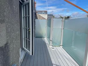 a balcony with an open window on a building at Luxurious apartment near the sea in Dun Laoghaire