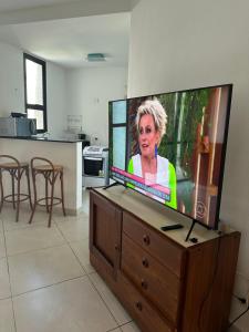 una TV a schermo piatto seduta sopra un centro di intrattenimento in legno di Apartamento Copacabana sistema Apart-hotel a Rio de Janeiro