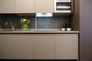 a kitchen with white cabinets and a vase of flowers at Emerald Green Residence in Caldiero