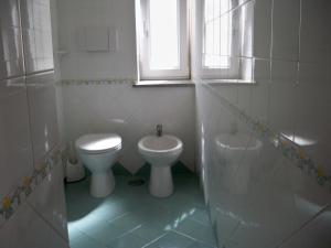 a white bathroom with a toilet and a bidet at L'Isolana Case Vacanza Alloro 1 in Ponza +4 photos