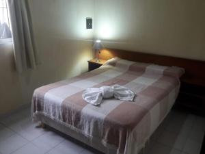 1 dormitorio con 1 cama con albornoz en Cabaña Lo De Leo en Concordia