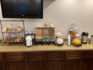 a kitchen counter with a counter top with bread and milk at Boarders Inn & Suites by Cobblestone Hotels - Munising in Wetmore