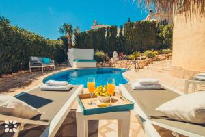 ベニタチェルにあるVilla Sea Breeze by Abahana Villasの- テーブルとオレンジジュース2杯付きのプール