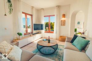 ein Wohnzimmer mit einem Sofa und einem Tisch in der Unterkunft Villa Sea Breeze by Abahana Villas in Benitatxell