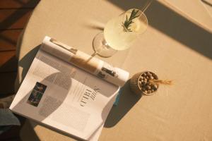 un magazine assis au-dessus d'une table avec un verre dans l'établissement Hotel Mühlbacherhof, à Lagundo