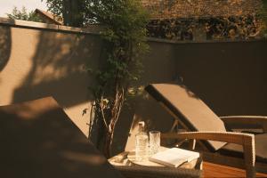 a table with a bottle and a chair on a patio at Hotel Mühlbacherhof in Lagundo