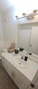 y baño con lavabo y espejo. en 3 bedroom Town in Stonebridge unit 303 en Saskatoon
