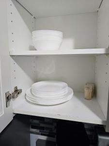 uma pilha de pratos e tigelas num armário de cozinha em 3 bedroom Town in Stonebridge unit 303 em Saskatoon