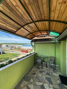 un patio con mesa, sillas y techo de madera. en Villa Oaza, en Bela Crkva