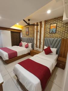 ein Hotelzimmer mit 2 Betten und roten Kissen in der Unterkunft Hotel RK ICON in Ahmedabad