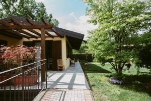 um alpendre de uma casa com uma pérgola de madeira em LA CASETTA Malpensa Guesthouse em Case Nuove