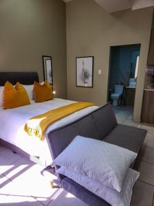 a bedroom with a large bed and a couch at No Loadshedding Fast WiFi Lux Apartment in Johannesburg