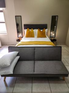 1 dormitorio con 1 cama grande con almohadas amarillas en No Loadshedding Fast WiFi Lux Apartment en Johannesburgo