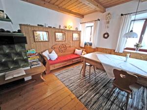 a living room with a red couch and a table at Bauernhof Geigerhof in Aschau im Chiemgau