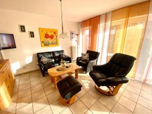 sala de estar con sillas de cuero y mesa en Tomke - Kolk 30, en Norddeich