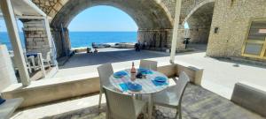 a table and chairs on a patio with a view of the ocean at La casa in riva al mare by LoveSud in Leuca