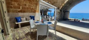 einen Tisch und Stühle auf einem Balkon mit Meerblick in der Unterkunft La casa in riva al mare in Santa Maria di Leuca