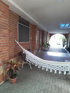 a hammock in a building with a brick wall at Pousada Solar do Lazer in Recife