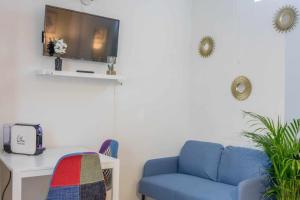 オルレアンにあるStudio Rue piétonne Orléansの青いソファとテレビのあるリビングルーム