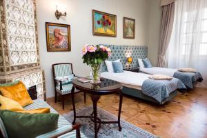 ein Wohnzimmer mit 2 Betten und einem Tisch mit Blumen in der Unterkunft Apartamenty Kamienica Muzyków Old Town Lublin in Lublin