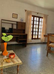 una sala de estar con una mesa con una planta en CASA DE LOS NONOS HOSPEDAJE en La Consulta