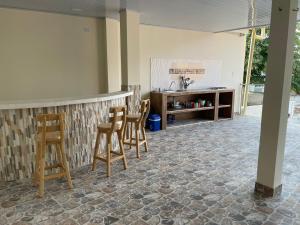 a kitchen with a bar with chairs and a counter at EL PARAISO DE GAIRA in Santa Marta