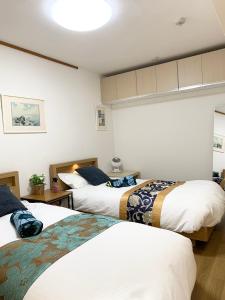 two beds in a room with two at Spring Apartment Shinjuku in Tokyo