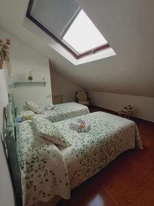 two twin beds in a room with a skylight at Hotel El Coterin Apartamentos y Habitaciones in Arenas de Cabrales