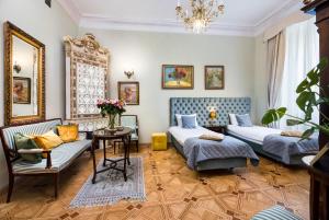 a living room with two beds and a table at Apartamenty Kamienica Muzyków Old Town Lublin in Lublin