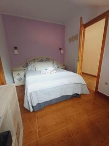 1 dormitorio con 1 cama blanca en una habitación en Hotel El Coterin Apartamentos y Habitaciones, en Arenas de Cabrales