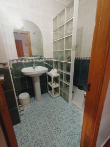 W łazience znajduje się umywalka i lustro. w obiekcie Hotel El Coterin Apartamentos y Habitaciones w mieście Arenas de Cabrales