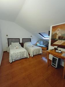 a bedroom with two beds and a table at Hotel El Coterin Apartamentos y Habitaciones in Arenas de Cabrales