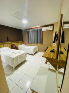 ein Hotelzimmer mit 2 Betten und einem Schreibtisch in der Unterkunft Borges Hotel in Imperatriz