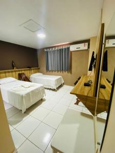 a hotel room with two beds and a desk at Borges Hotel in Imperatriz