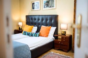 a bedroom with a bed with orange and blue pillows at Apartamenty Kamienica Muzyków Old Town Lublin in Lublin