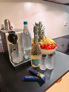 a counter with a bottle of alcohol and a bowl of fruit at De Lux apartment! Great location! Bohemic getaway! in Helsinki