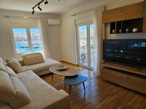 a living room with a couch and a flat screen tv at Piraeus center sea view apartment in Piraeus