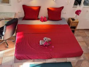 Indawood في Saint Barthelemy: غرفة نوم بها سرير عليه شراشف حمراء وزهور