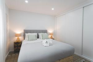 Un dormitorio con una gran cama blanca con dos lámparas. en Best Houses 100 - Point Break 12, en Peniche